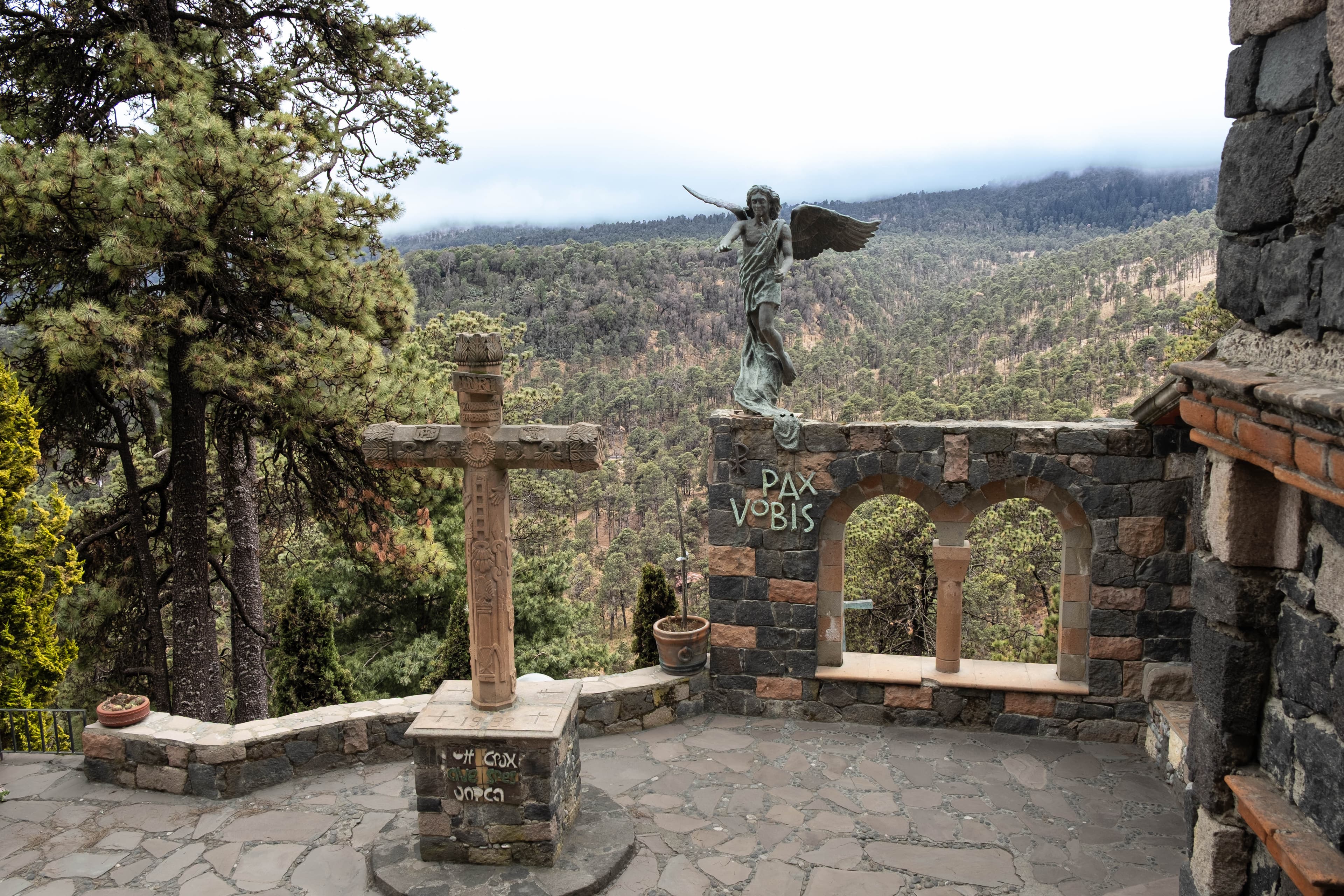 Terraza con la cruz y el ángel, abierta al bosque nublado